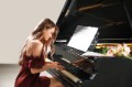 Young woman playing grand piano at the concert