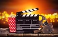 Retro film production accessories placed on wooden planks. Concept of film-making. Blur spot lights on background
